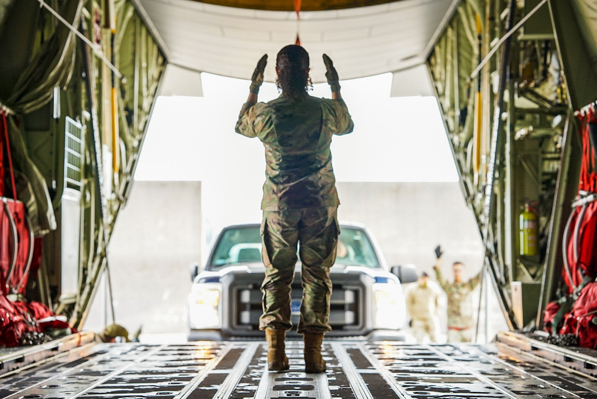 An Airmen leads in a truck to a C-130j Super Hercules