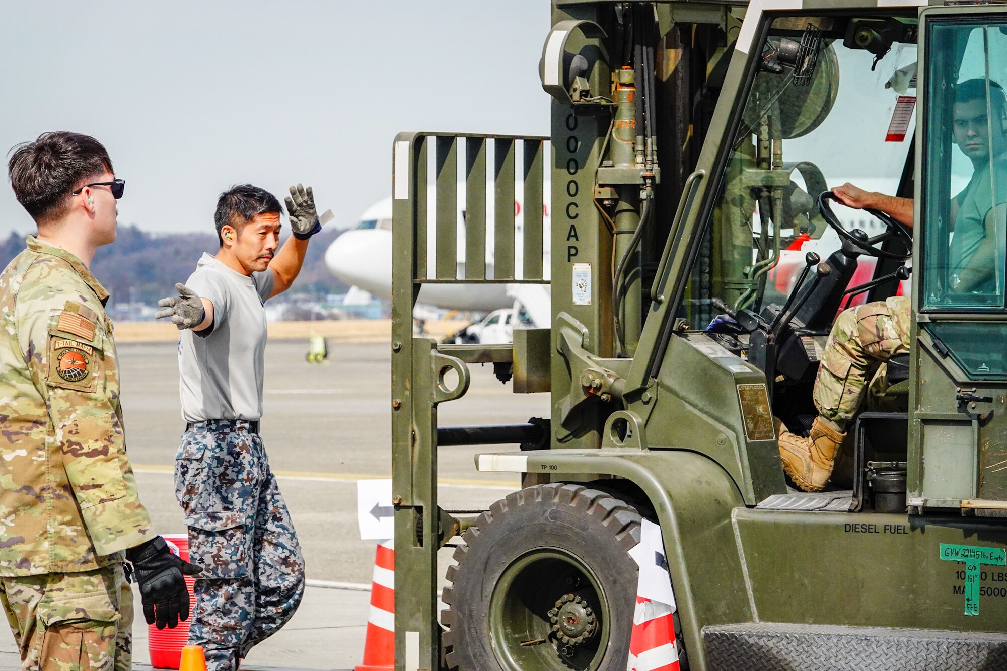 Service members participate in forklift driving challenge.