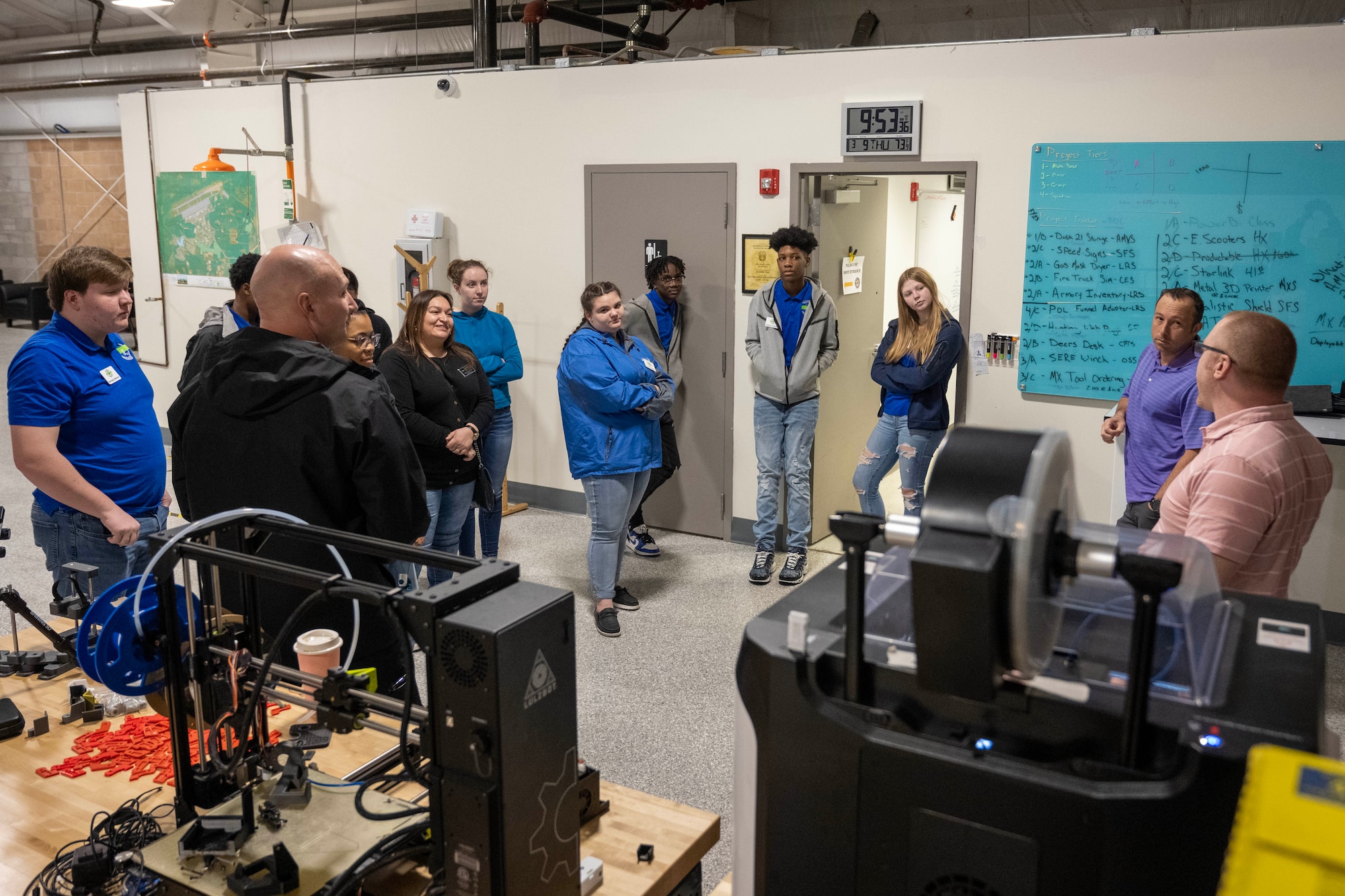 Students tour a facility with equipment in the foreground.