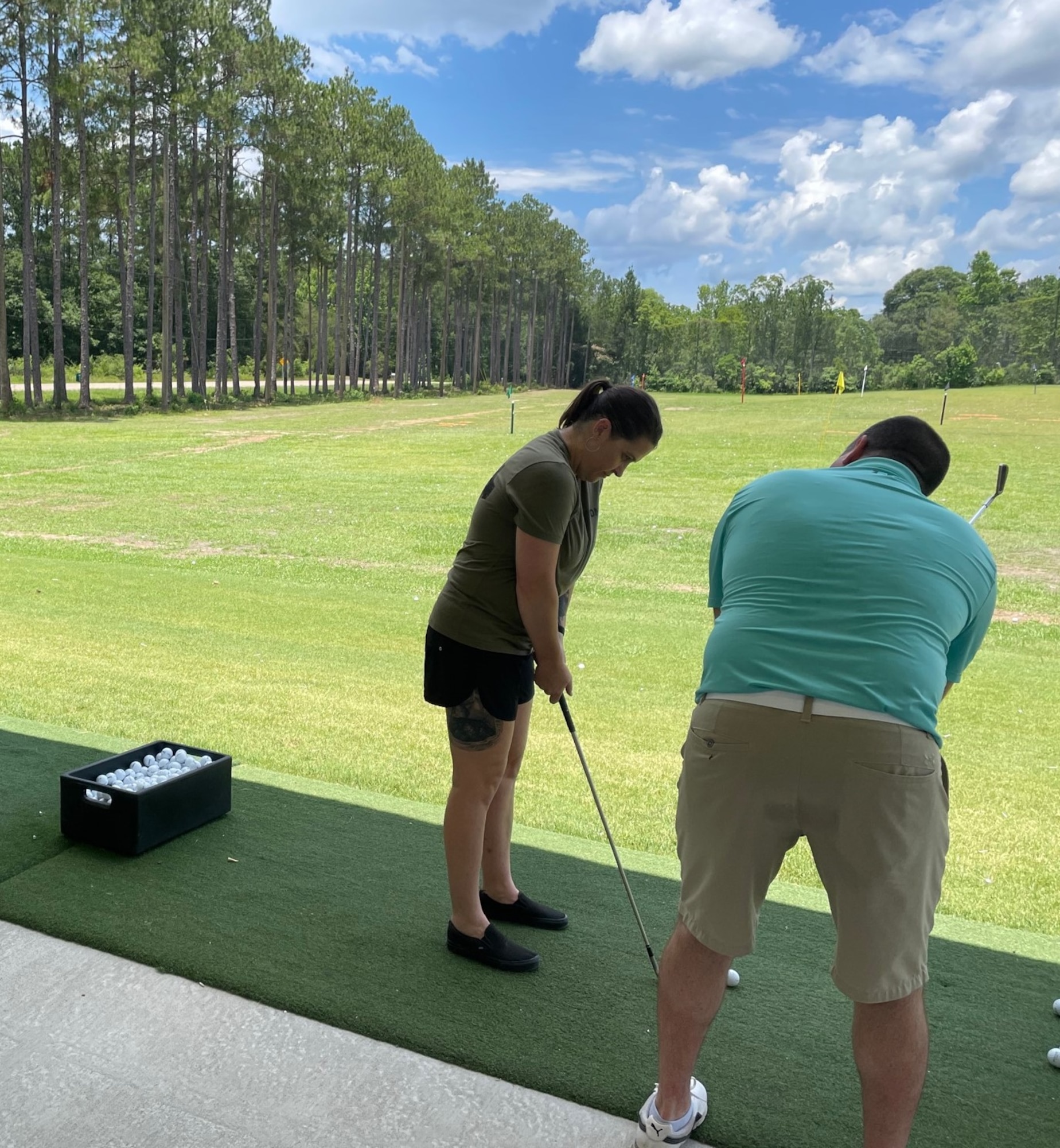 a woman preps to hit a golf tee