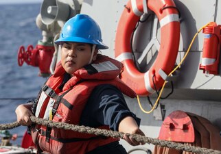 Cryptologic Technician (Collection) Seaman Natalie Uraje, heaves a line aboard USS Milius (DDG 69) during an underway replenishment.