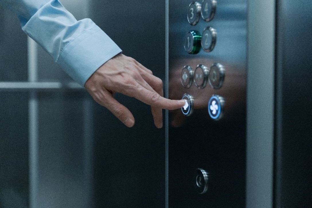 Finger pressing a button on an elevator