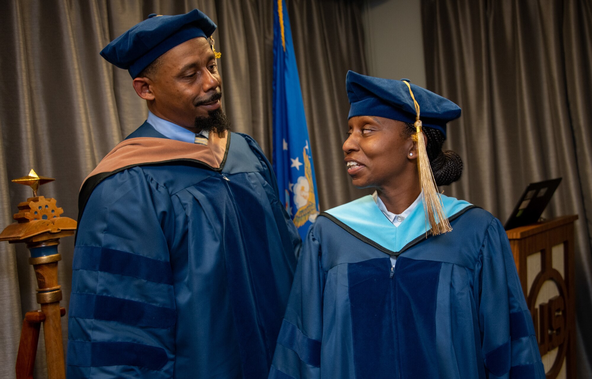 Senior Master Sgt. Anique S. McElveen receives her doctorial hood from her husband Dr. Chris McElveen during a ceremony at the Enlisted Heritage Hall on Maxwell Air Force Base, Gunter Annex, March 10, 2023.  She is part of just .007 percent of enlisted Airmen to receive a doctoral degree. McElveen is the superintendent of the College of Academic Management at the Community College of the Air Force. (U.S. Air Force photo/Brian Ferguson)