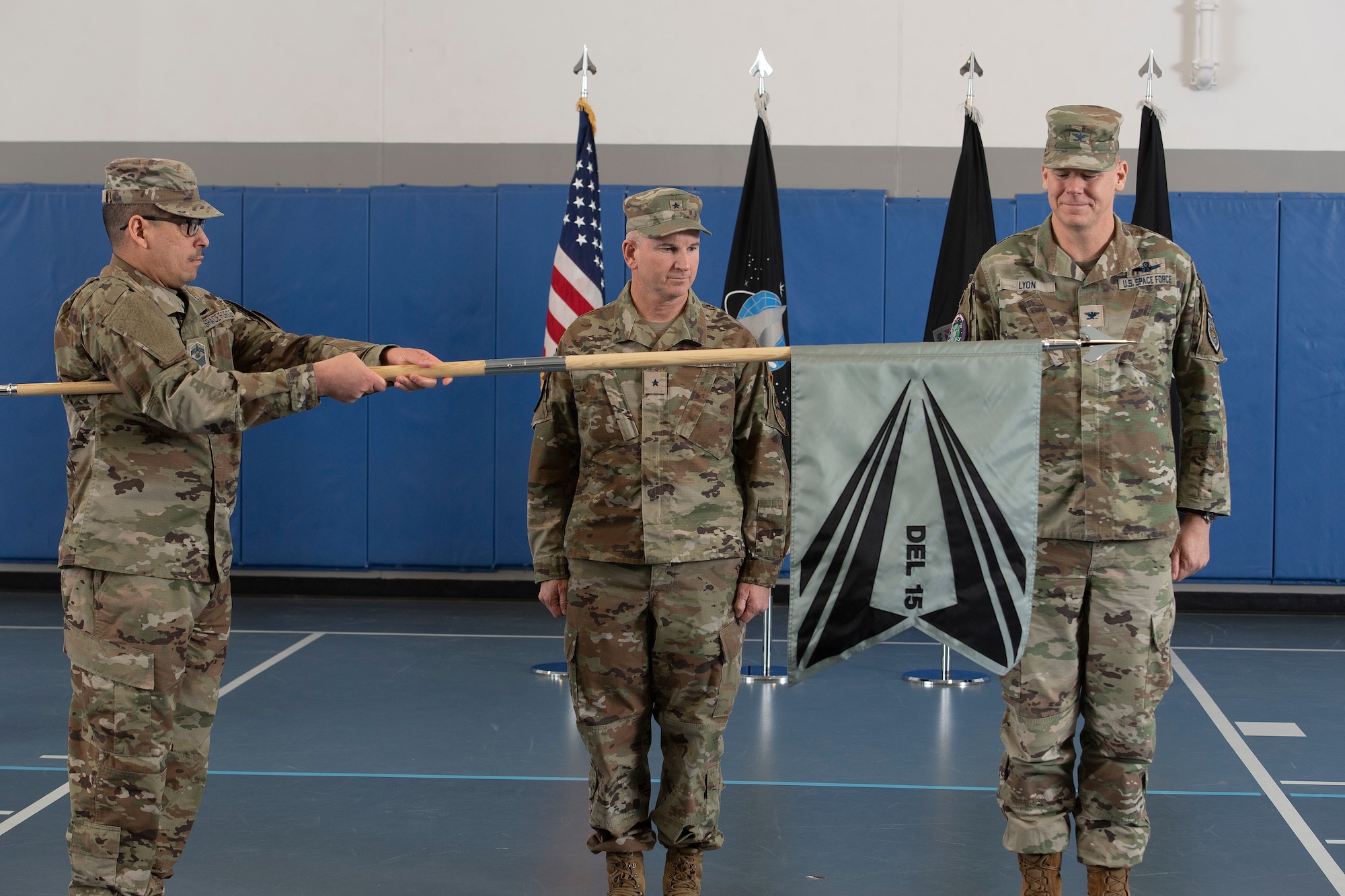From left, U.S. Space Force Senior Master Sgt. Kristopher-Michael K. Kainoa, Space Delta 15 senior enlisted leader, unveils the DEL 15 guidon as U.S. Space Force Brig. Gen. Dennis Bythewood, Joint Task Force-Space Defense commander and U.S. Space Force Col. Stephen Lyon, DEL 15 commander, stand at attention during the DEL 15 activation ceremony at Schriever Space Force Base, Colorado, March 10, 2023. The mission of DEL 15 is to provide service command-and-control (C2) capability, mission ready crew forces, skills training, certifications, intelligence, surveillance, and reconnaissance (ISR), and support and cyber mission defense, and special mission support to the JTF-SD and its National Space Defense Center. (U.S. Space Force photo by Dennis Rogers)