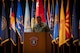 man wearing u.s. army uniform stands behind a podium.