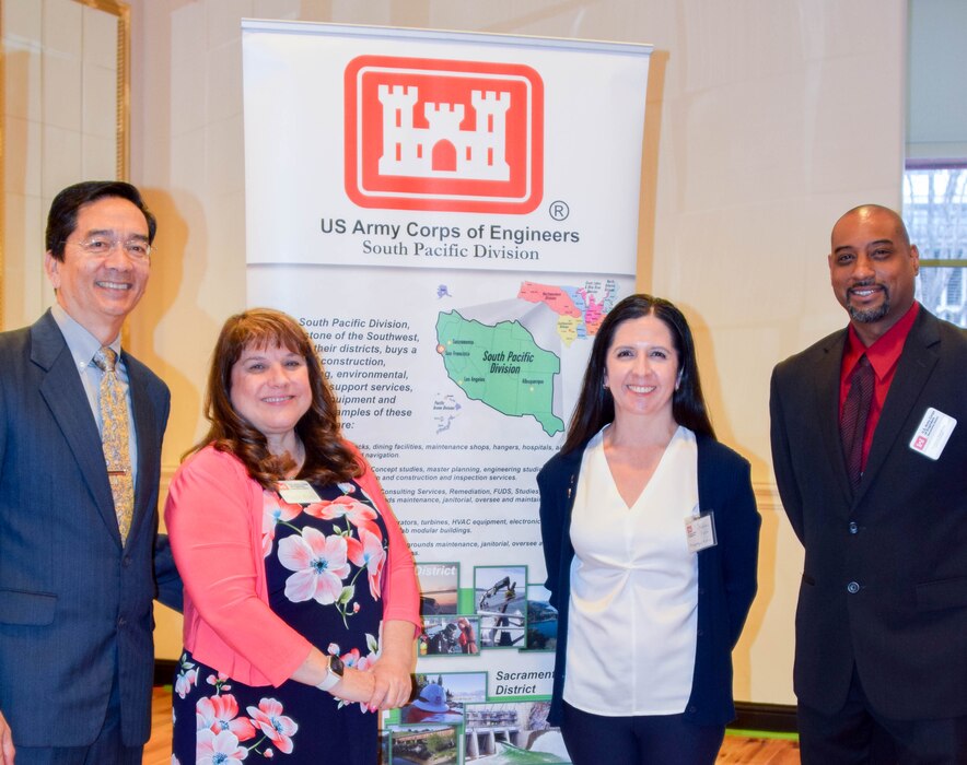 (Left to right) Jack May (USACE-South Pacific Division, Assistant Director), Michelle Morales (USACE- Sacramento District, Deputy for Small Business), Stephanie Parra (USACE- Albuquerque District, Deputy for Small Business) and Vernon Simpkins (USACE- Sacramento District, Deputy for Small Business pose for a photo in front of a USACE South Pacific Division infographic poster at the annual Business Opportunities Open House on March 7, 2023. The annual BOOH event is hosted to offer prospective contractors to network with USACE staff members and learn about our incoming workload for the next several years. 