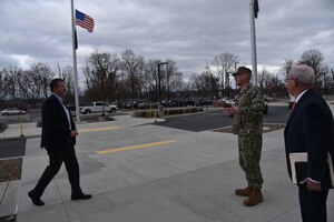 Brad Bunn meets Rear Adm. Grafton D. Chase, Jra nd Perry L. Knight outside of DLA Distribution with flags in the background
