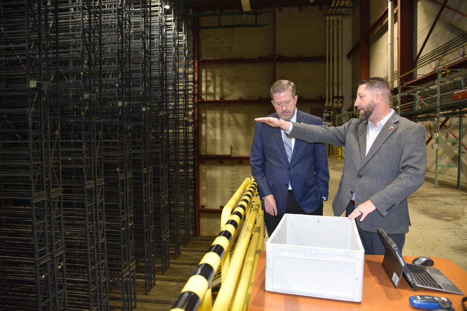 Brad Bunn and Tim Kosky observe racks of storage from an elevated platform in a warehouse