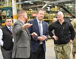 DLA Vice Director Brad Bunn watches as modernization project manager Tim Kosky briefs in a warehouse