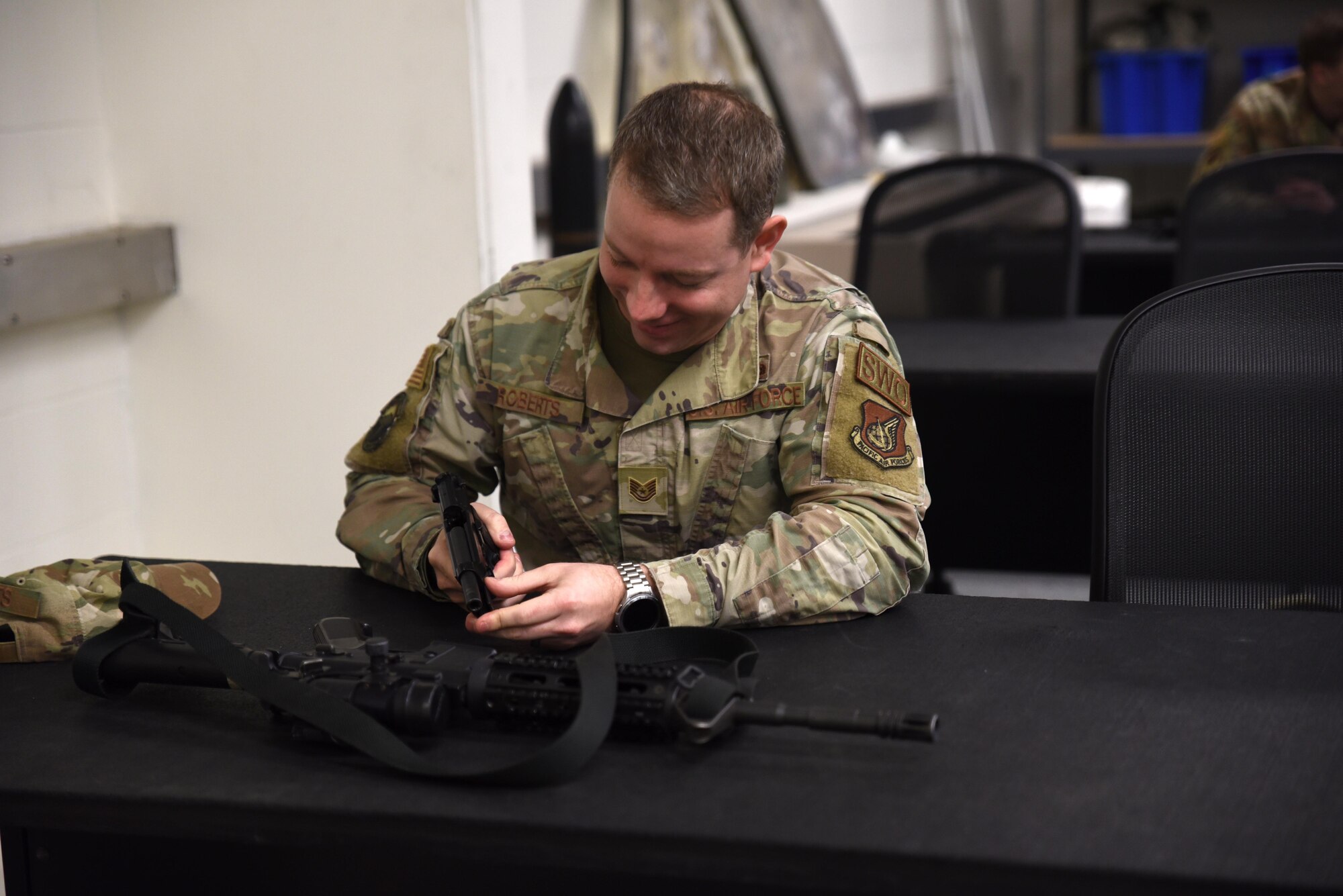 U.S. Air Force Tech. Sgt. Jonathan Roberts, brigade noncommissioned officer in charge with the 1st Combat Weather Squadron, reviews how to handle a weapon at Joint Base Lewis-McChord, Washington, March 9, 2023. Weapons qualifications trainings are held to ensure service members are deployment ready. (U.S. Air Force photo by Airman Kylee Tyus)