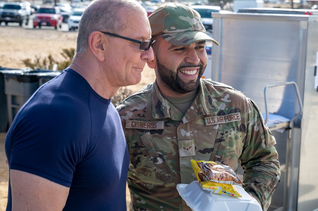 Celebrity Chef Robert Irvine takes a photo with a 412th Security Forces Airman during the Breaking Bread for Heroes event at Edwards Air Force Base, California, March 10.