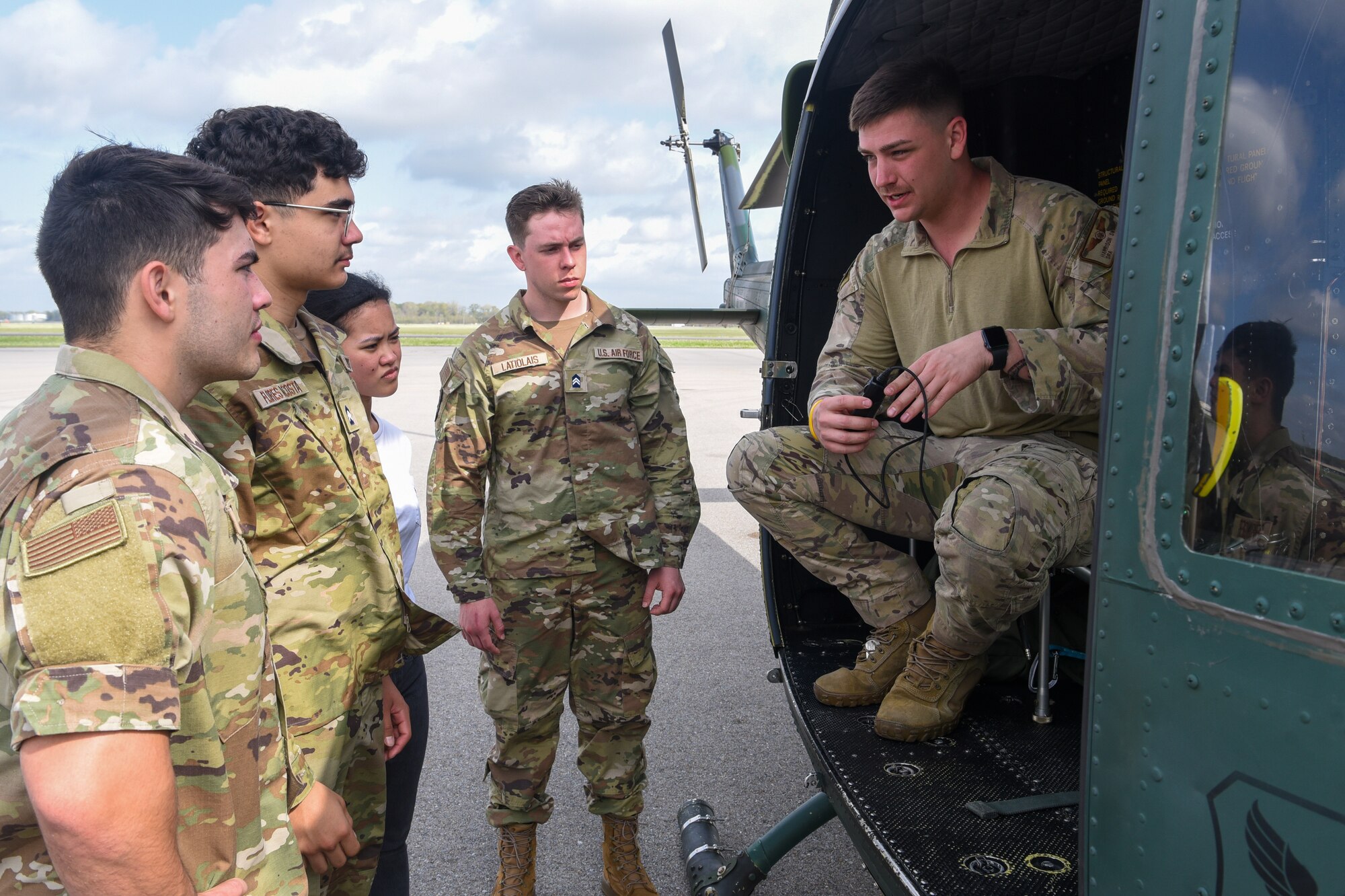 flight engineer shows four ROTC cadets helicopter equipment