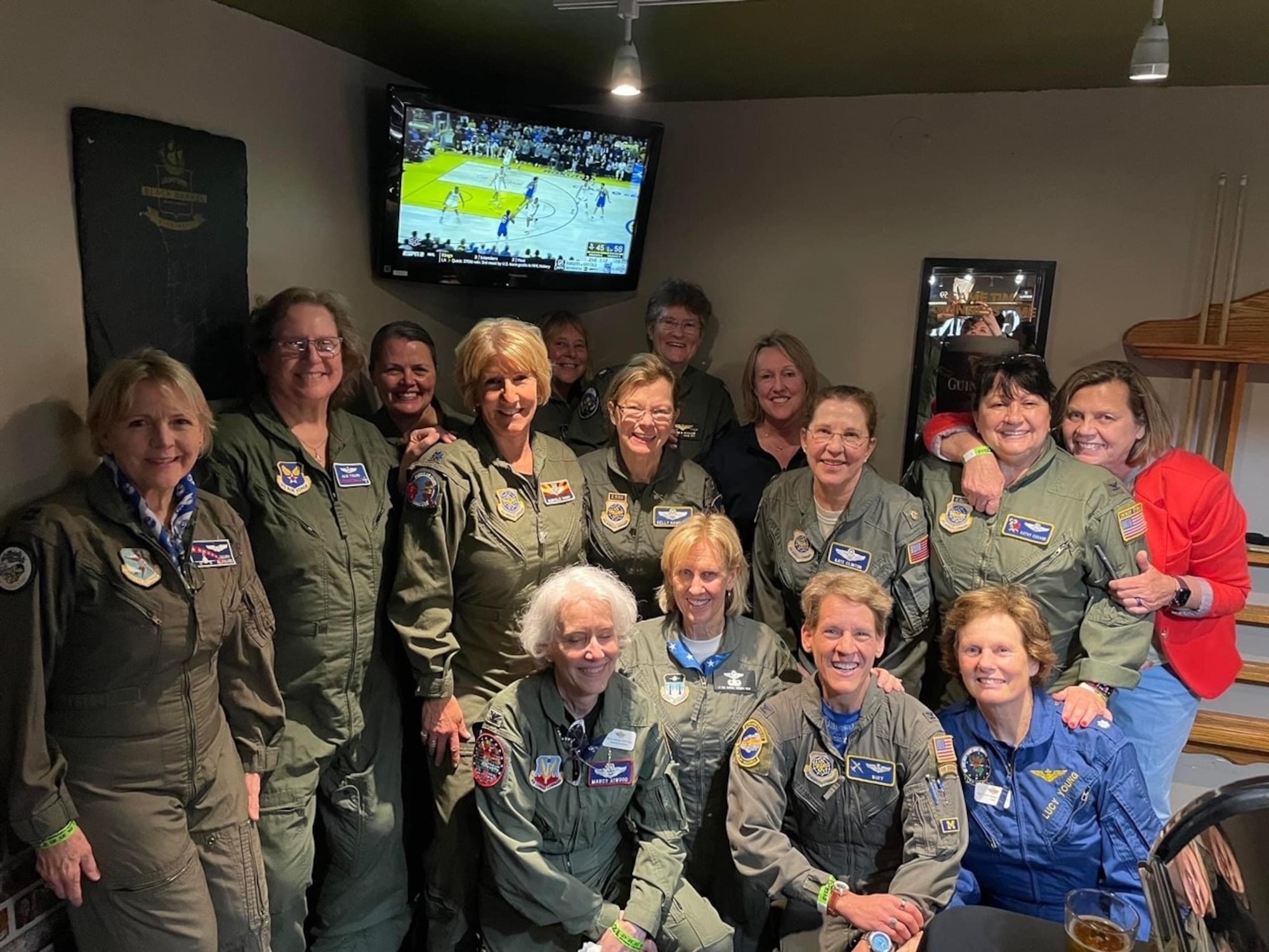 women in flight suits smile at camera