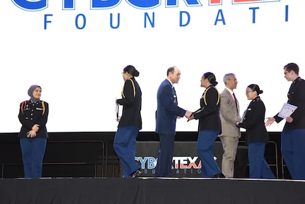 Lt Gen Kevin Kennedy, commander 16 Air Force (AFCYBER), gave 16 AF coins to each member of the winning CyberPatriot team, congratulating each for a job well done during the San Antonio Mayor's Cyber Cup Awards Luncheon, Saturday, Feb 25.