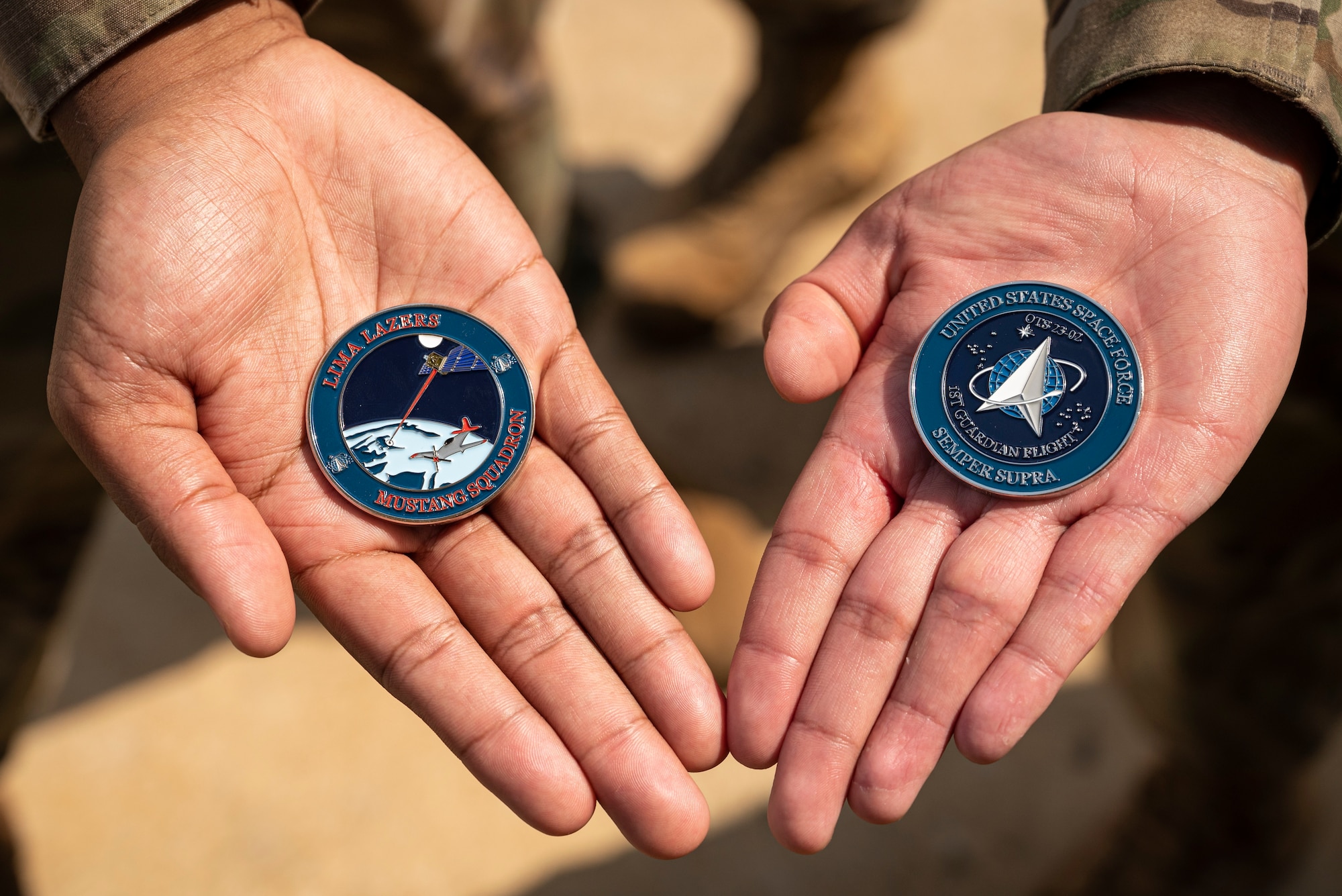 A newly minted challenge coin commemorates Officer Training School’s Lima Flight as the first all-Space Force Guardian flight to commission at OTS, as depicted on the coin on right. The coin on the left pays tribute to the Tuskegee Airmen, the namesake of the OTS Mustangs student squadron, in which the flight is assigned.