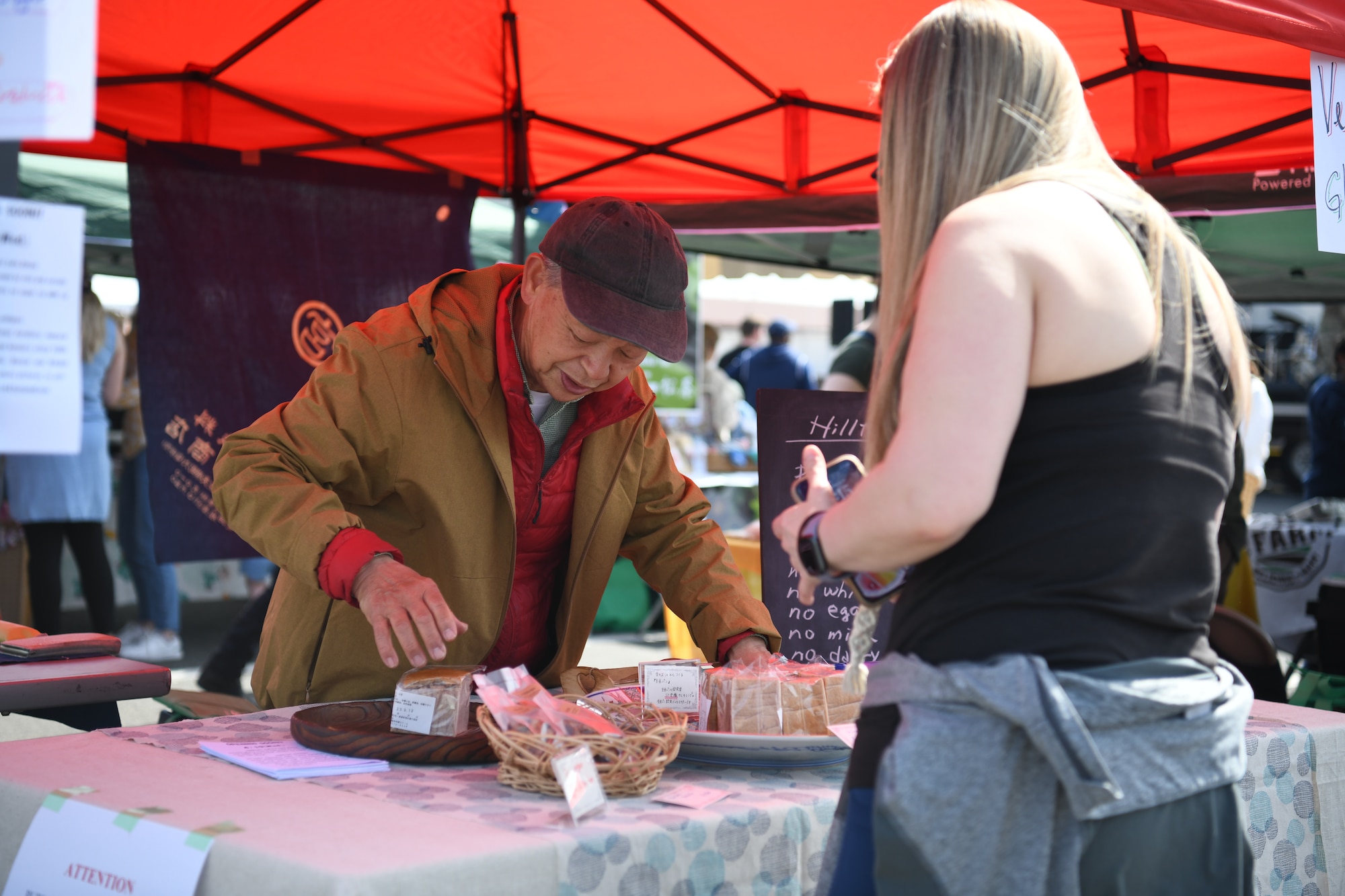 A white woman speaks with a Japanese man.