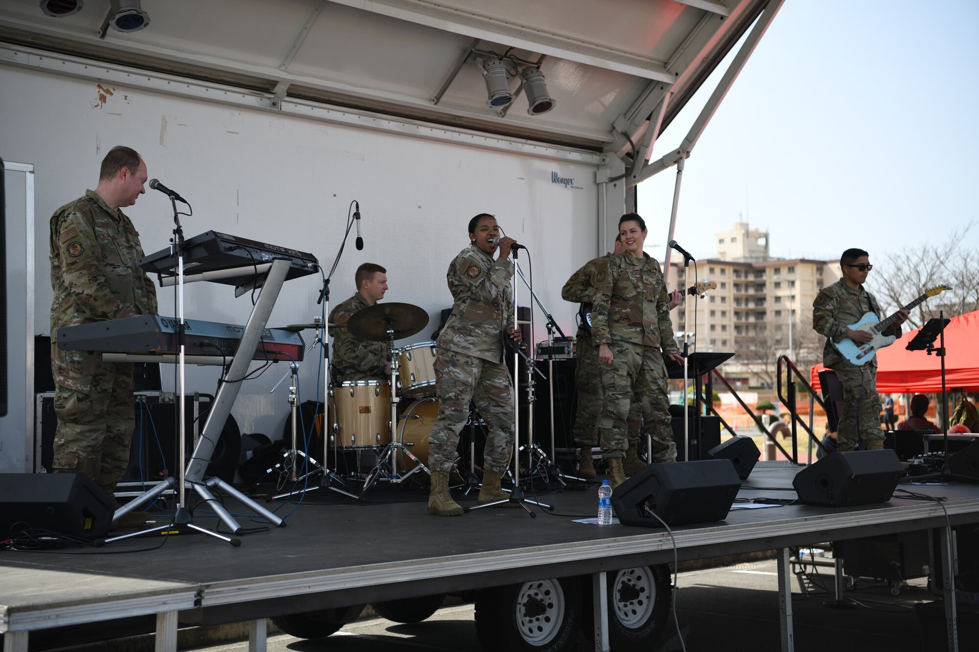 A group of men dressed in uniform perform on a stage.
