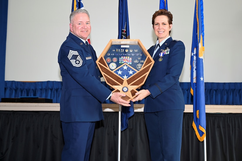U.S. Air National Guard Col. Christine E. Munch, right, 111th Mission Support Group Commander, accepts a shadowbox from U.S. ANG Chief Master Sgt. Brian E. Zarilla, 111th MSG Senior Enlisted Leader, during her retirement ceremony held at Biddle Air National Guard Base in Horsham, Pennsylvania, March 5, 2023. Munch was retired during the ceremony and honored for nearly 36 years of military service. (Air National Guard Photo by Airman 1st Class Charles Casner)
