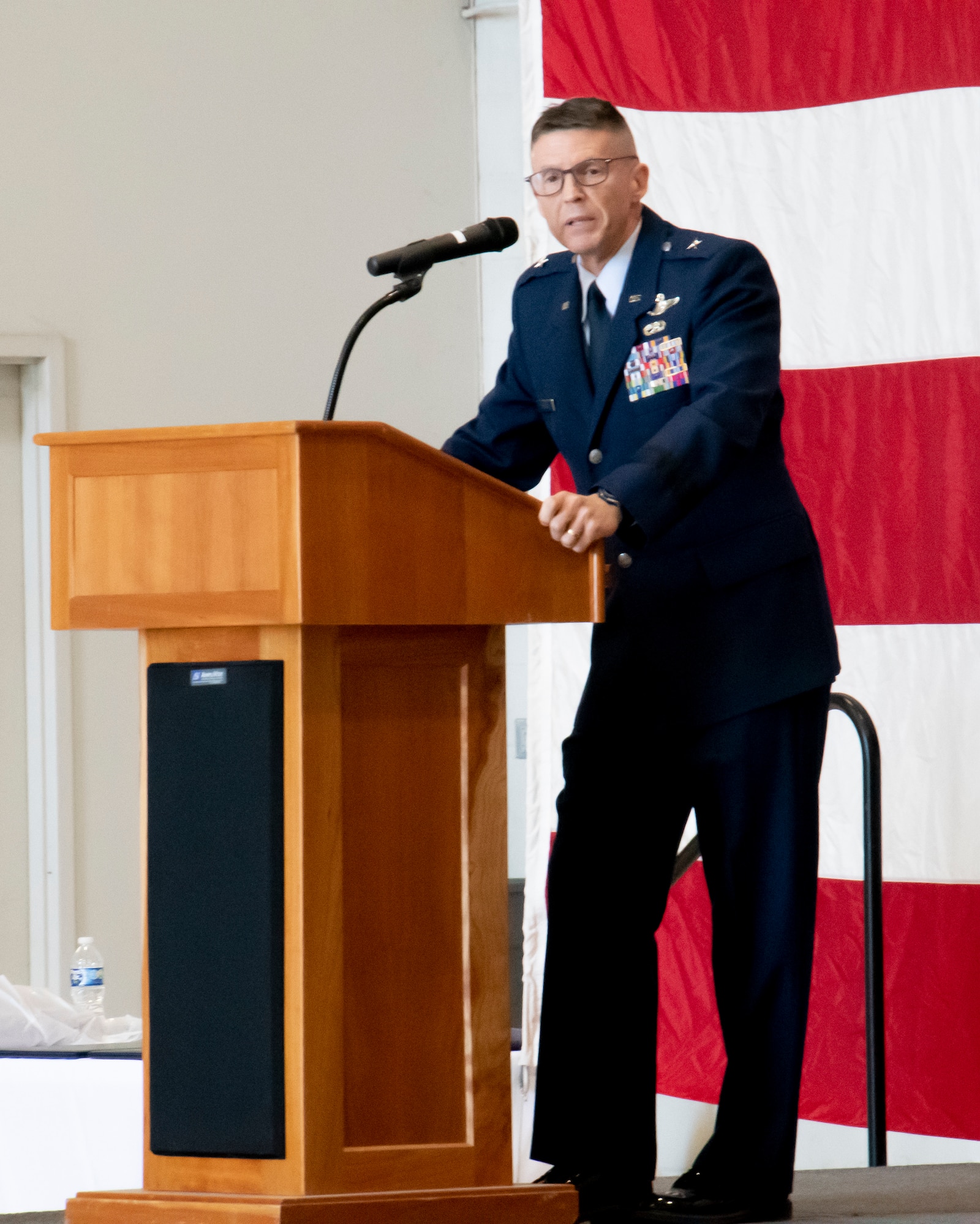 Service member leans on podium while speaking.