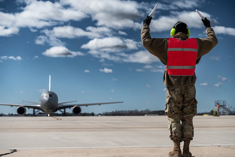 U.S. Air Force Airman 1st Class Alique Williams, 605th Aircraft Maintenance Squadron crew chief, marshals in a KC-46A Pegasus for an Engine Running Crew Change at Joint Base McGuire-Dix-Lakehurst, N.J., March 8, 2023.