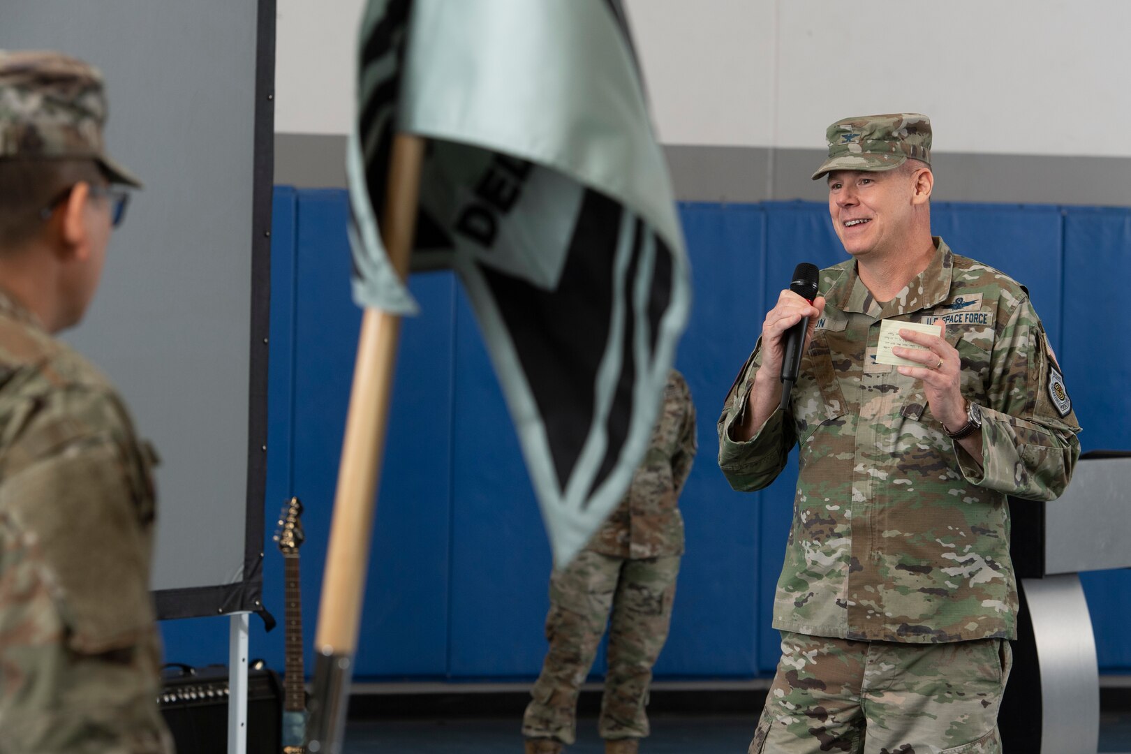 Man in military uniform speaking into microphone