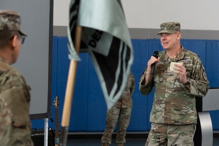 Man in military uniform speaking into microphone