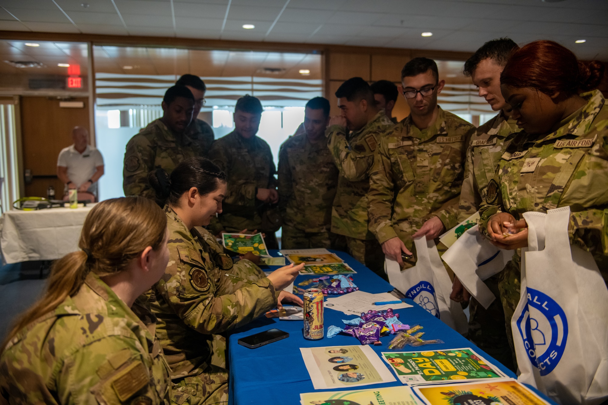 Airman stand gathered around a booth