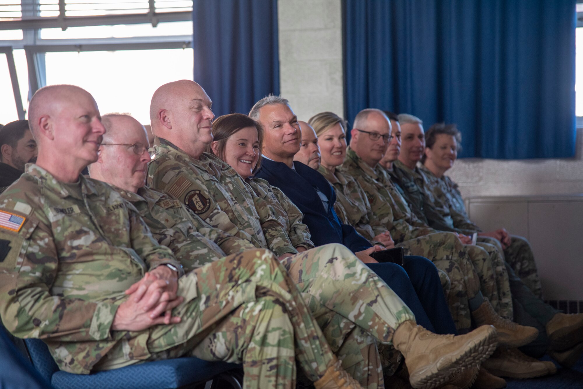 People in uniform sit in an auditorium.