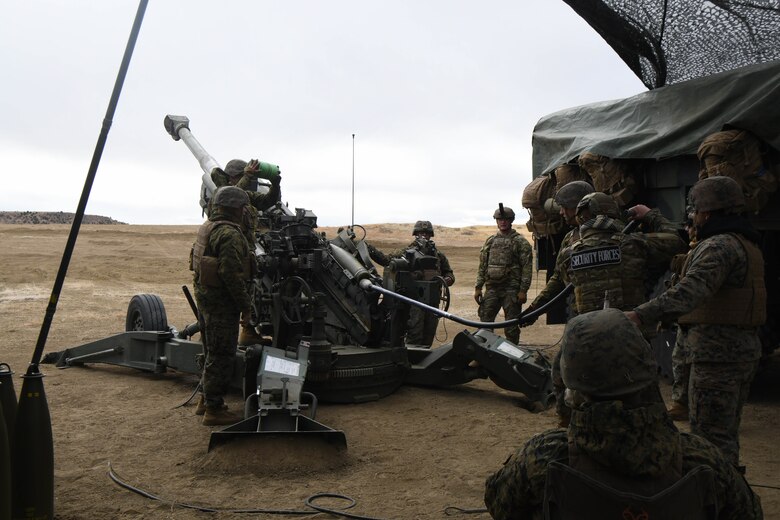 Service members load a cannon