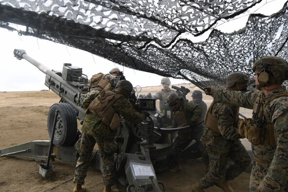 Service members load a cannon