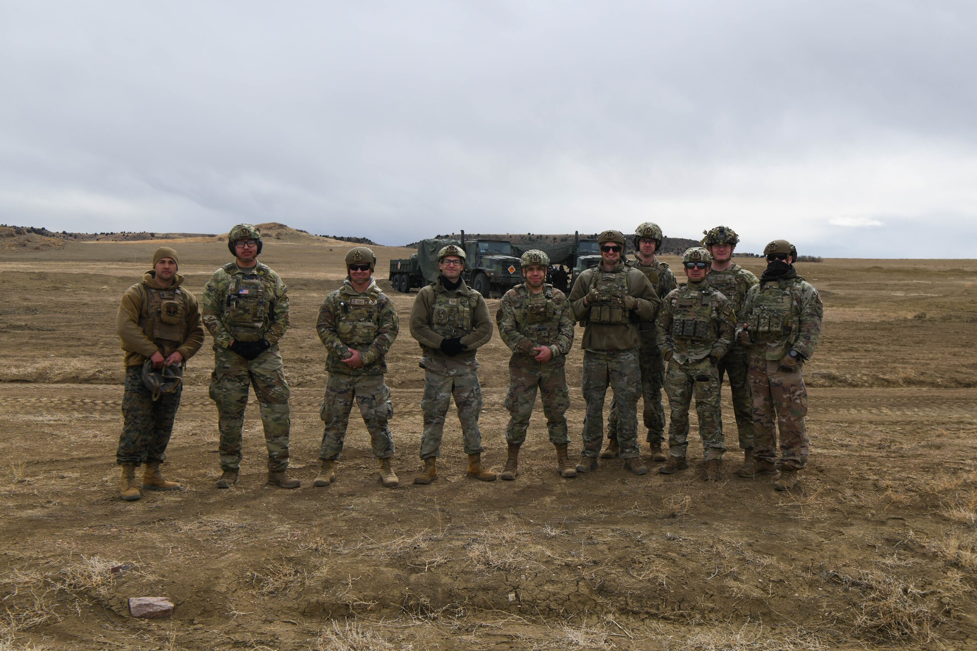Service members stand in a field