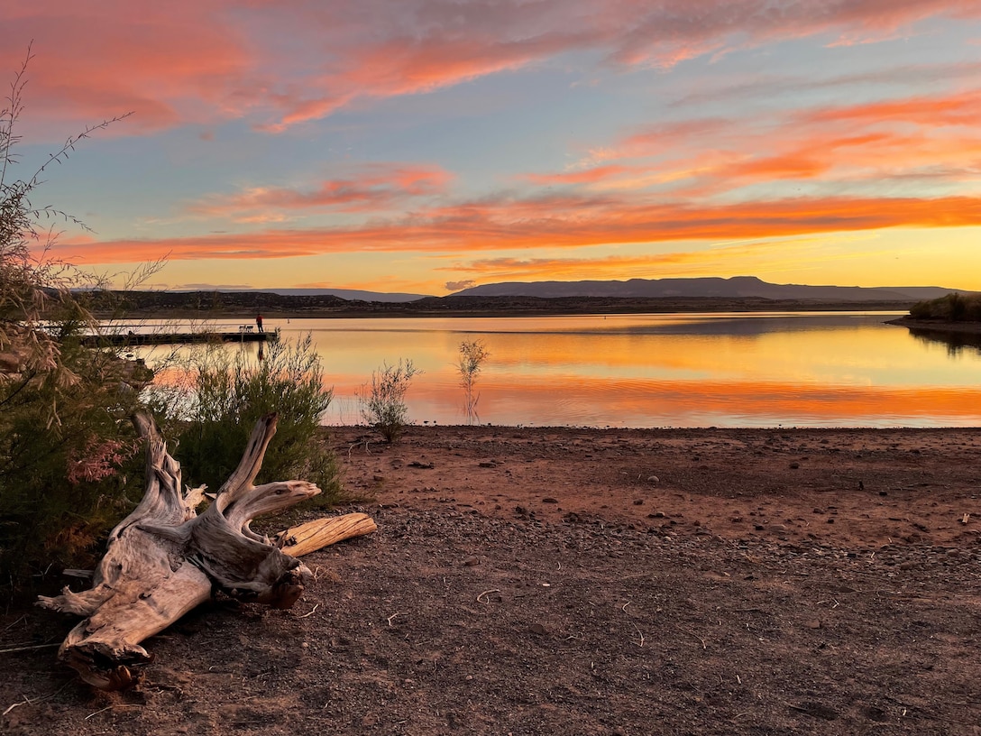 ABIQUIU LAKE, N.M. – A visitor watches the sunset over the lake from the dock in the distance, June 20, 2022. Photo by Pamela Bowie. This photo placed first, based on employee voting.