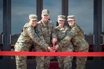 Service members cutting a red ribbon for a grand re-opening