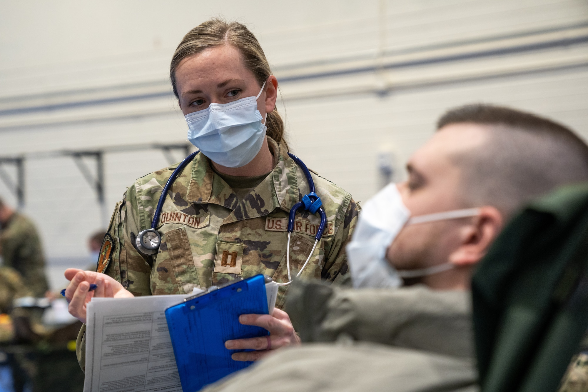 U.S. Air Force Capt. Andrea Quinton stands next to a patient laying in a cot