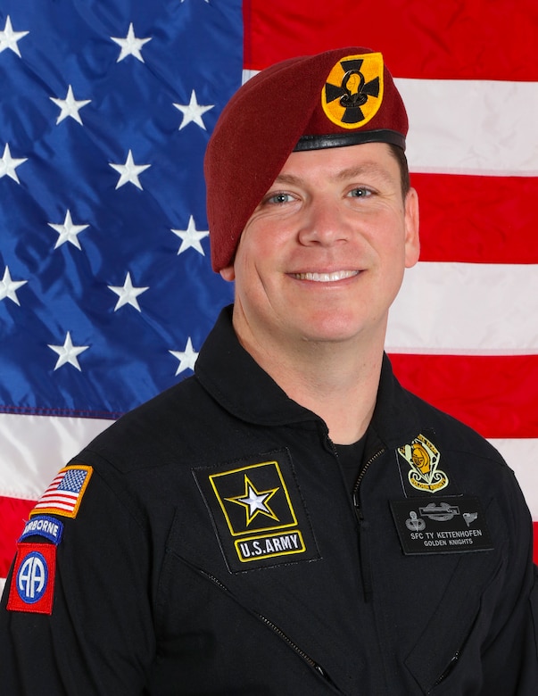 man standing in front of two flags.