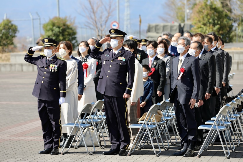 Senior leaders and other guests stand to honor the arrival of the Japanese and American flags and the playing of both countries’ anthems March 4 during a ceremony marking the JGSDF’s 10-year anniversary co-located on the Camp Zama with the U.S. Army in Japan.
