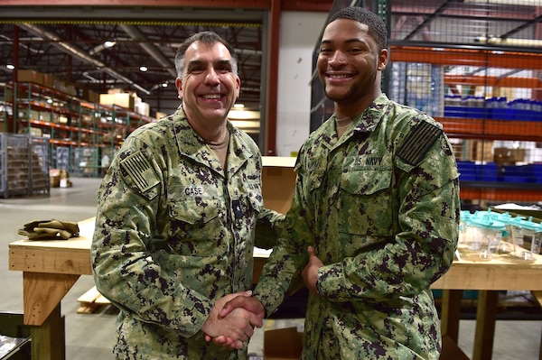 Rear Adm. Matthew Case, Naval Medical Forces Atlantic (NMFL) commander and director, Tidewater Market, presents a coin to Logistics Specialist Seaman C. Williams, assigned to Navy Medicine Readiness and Training Command (NMRTC) Portsmouth.