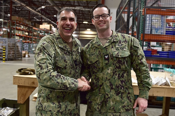 Rear Adm. Matthew Case, Naval Medical Forces Atlantic (NMFL) commander and director, Tidewater Market, presents a coin to Logistics Specialist 3rd Class Christian Thomas, assigned to Expeditionary Medicine Facility (EMF) Juliet at Navy Medicine Readiness and Training Command (NMRTC) Portsmouth.