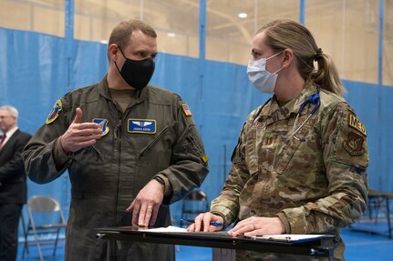 U.S. Air Force Lt. Col. Joshua Eaton stands next to Capt. Andrea Quinton in front of a patient