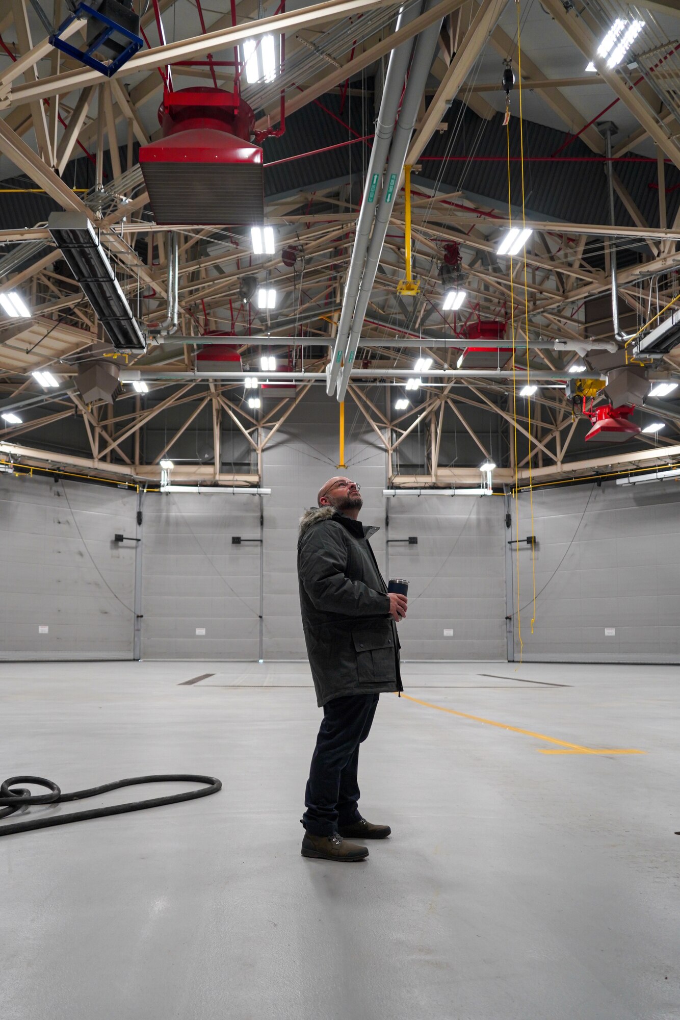 Man looks up at the ceiling of a hangar.