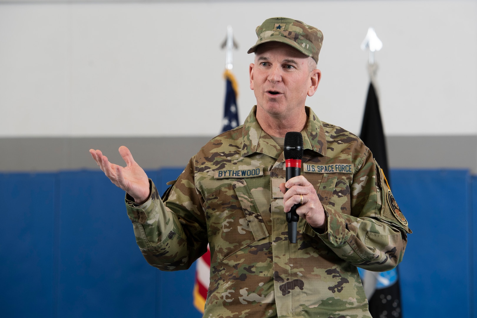 Man in military uniform speaking into microphone