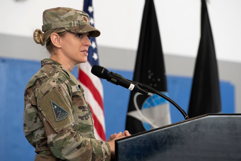 Woman in uniform at podium speaking into microphone