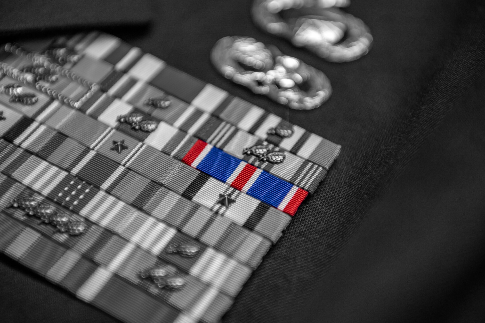 The 22nd Air Refueling Wing Air Force Outstanding Unit Award is added to the ribbon rack of a master sergeant's service dress coat March 6, 2023. The Wing earned the award for 2022 by making innovational and operational waves felt across the entire service. (U.S. Air Force photo illustration by Master Sgt. John Gordinier)