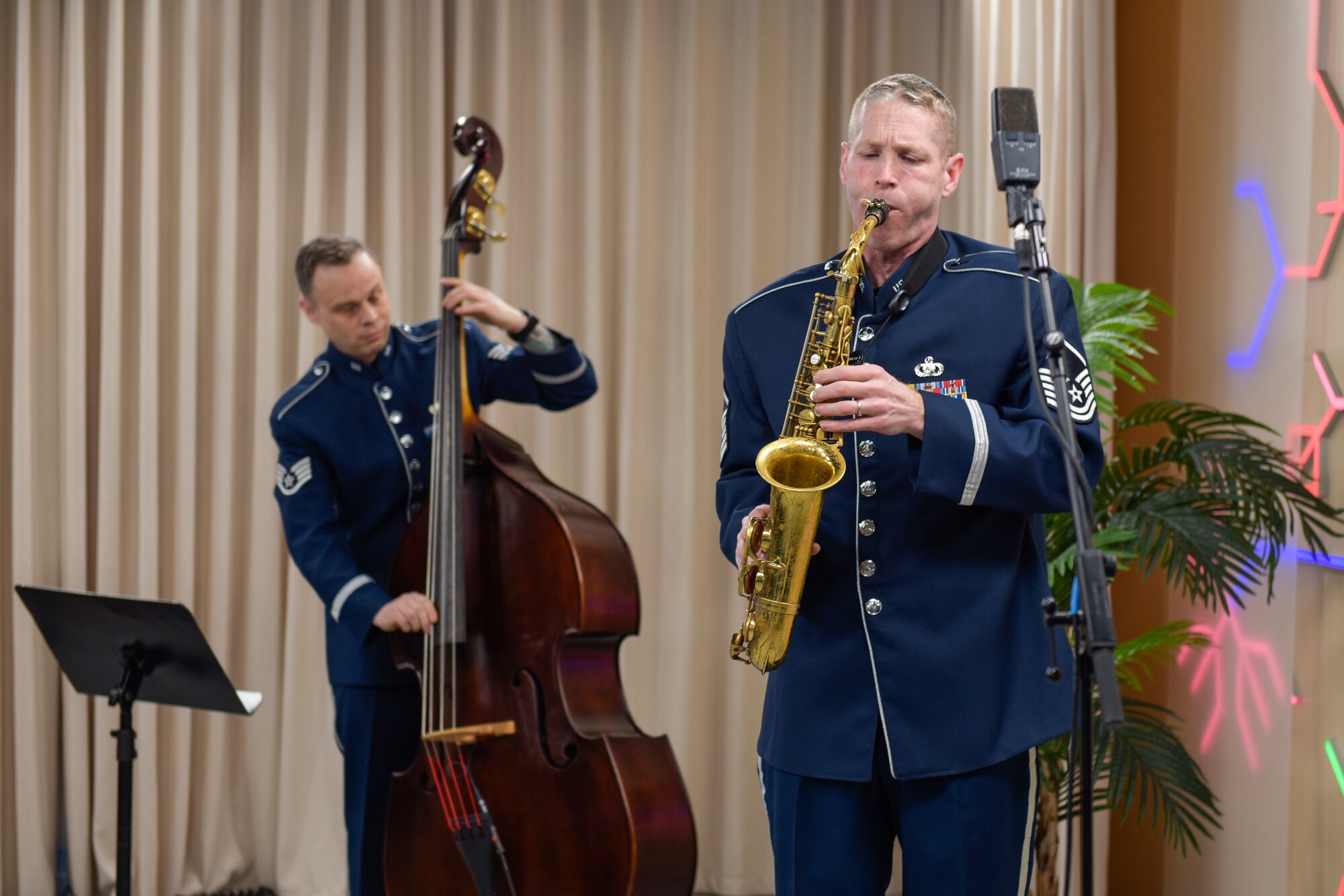 Two people play a bass and a saxophone