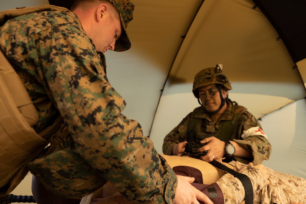 A U.S. Navy corpsman with the 31st Marine Expeditionary Unit, and a soldier with the 1st Amphibious Rapid Deployment Regiment, Japan Ground Self-Defense Force, asses the injuries of a simulated casualty during a casualty evacuation exercise on Kin Blue, Okinawa, Japan, on March 10, 2023. The training enabled the bilateral medical team to practice in-route care and shock trauma field training during Iron Fist 23. Iron Fist is an annual bilateral exercise designed to increase interoperability and strengthen the relationships between the U.S. Marine Corps, the U.S. Navy, the JGSDF, and the Japan Maritime Self-Defense Force. (U.S. Marine Corps photo by Lance Cpl. Bridgette Rodriguez)