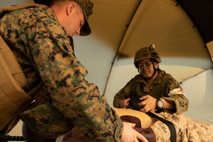 A U.S. Navy corpsman with the 31st Marine Expeditionary Unit, and a soldier with the 1st Amphibious Rapid Deployment Regiment, Japan Ground Self-Defense Force, asses the injuries of a simulated casualty during a casualty evacuation exercise on Kin Blue, Okinawa, Japan, on March 10, 2023. The training enabled the bilateral medical team to practice in-route care and shock trauma field training during Iron Fist 23. Iron Fist is an annual bilateral exercise designed to increase interoperability and strengthen the relationships between the U.S. Marine Corps, the U.S. Navy, the JGSDF, and the Japan Maritime Self-Defense Force. (U.S. Marine Corps photo by Lance Cpl. Bridgette Rodriguez)