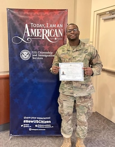 Sgt. Osse Jeanpierre shows off his U.S. citizenship certificate following his swearing in as a U.S. citizen Dec. 15, 2022, in Tukwila, Wash. The Washington National Guard member left Haiti as a 9-year-old.