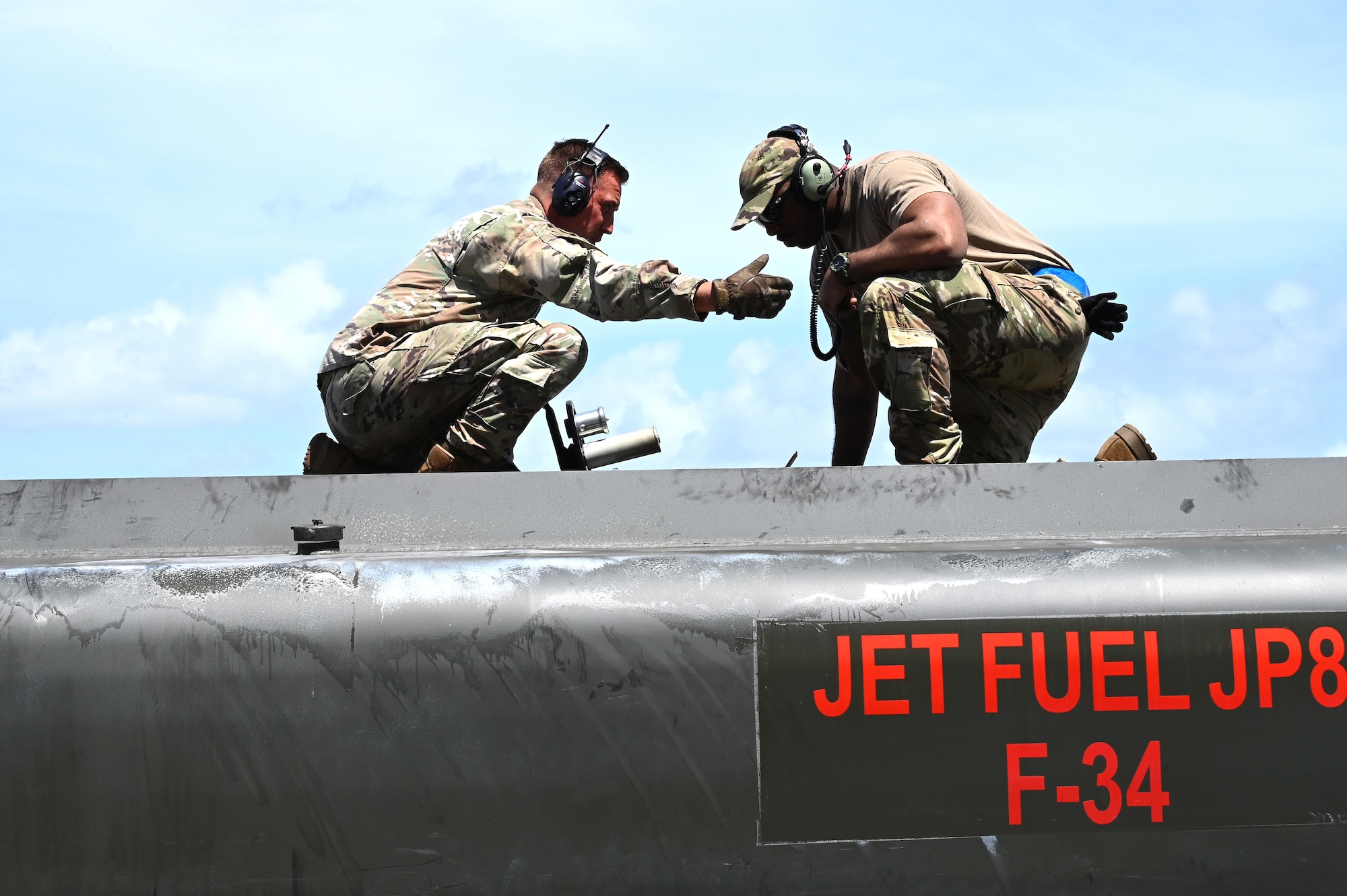 Tech. Sgt. Jordan Laughlin, left, the fuels distribution section chief assigned to the 3rd Air Expeditionary Wing, explains fuel levels in an R-11 refueling truck to Tech. Sgt. Brandon Bryant, right, a flying crew chief with the 703rd Aircraft Maintenance Squadron, Joint Base Elmendorf-Richardson, Alaska, during Exercise Agile Reaper 23-1 at Tinian International Airport, Northern Mariana Islands, March 3, 2023. Offloading fuel from a C-17 into an R-11 refueling truck allows fuels distribution operators the ability to rapidly refuel other aircraft in an Agile Combat Employment scenario by bypassing the need for fuel bladders or storage containers. (U.S. Air Force photo by Tech. Sgt. Hailey Staker)