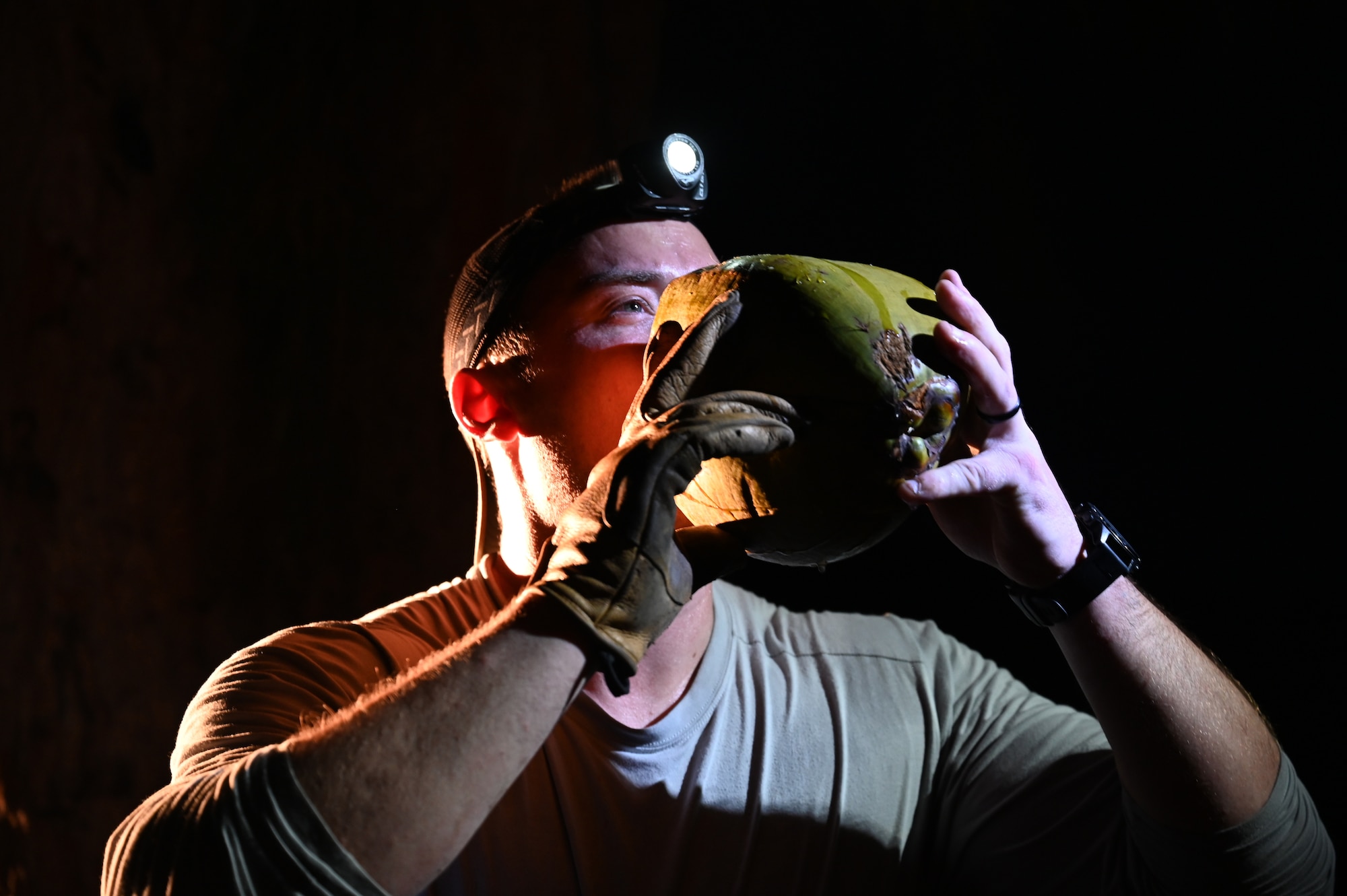 Tech. Sgt. Jared Biller, a Survival, Evasion, Resistance, and Escape specialist assigned to the 3rd Air Expeditionary Wing, drinks fresh coconut water from a coconut during Exercise Agile Reaper at Chulu Beach, Tinian, Northern Mariana Islands, March 3, 2023. SERE specialists utilized AR 23-1 to test and validate various survival equipment for Agile Combat Employment to be able to be self-sustaining in an austere environment. Some challenges members can face in these environments include weather and cloud cover, which can affect equipment like solar charging panels. (U.S. Air Force photo by Tech. Sgt. Hailey Staker)