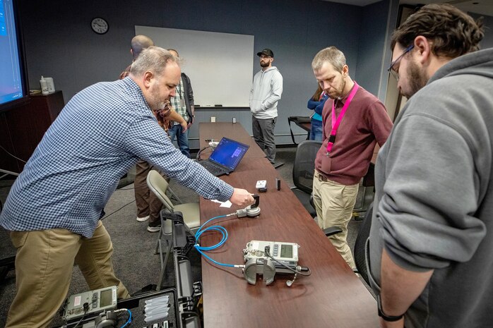 Micah Rollins, left, manager of research and development and manufacturing for Radiation Safety & Control Services, Inc., leads a training session on new reactive RADIAC equipment Dec. 7, 2022, at Puget Sound Naval Shipyard & Intermediate Maintenance Facility in Bremerton, Washington. (U.S. Navy photo by Scott Hansen)